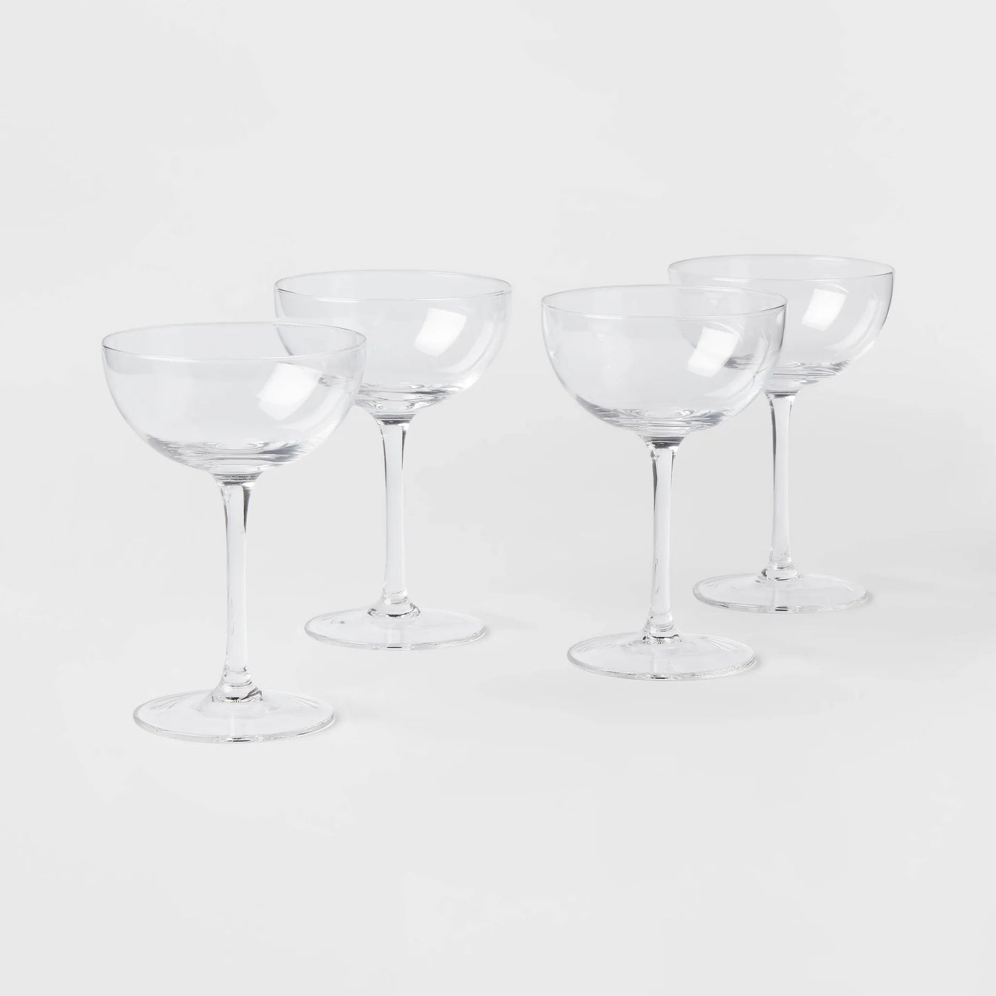 Elegant 4-pack of Threshold glass cocktail coupe glasses, perfect for serving champagne or cocktails.